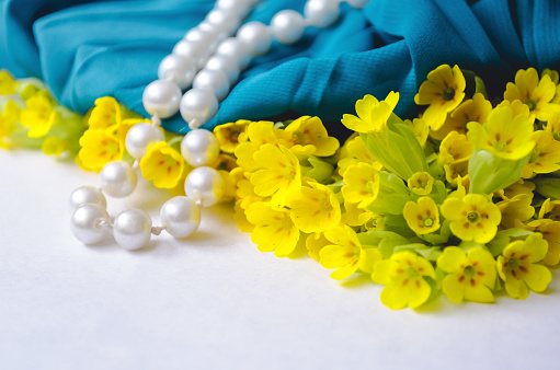 Small yellow flowers with a pearl bracelet.