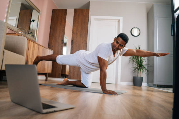 istock African-American fitness instructor explaining exercise in front of laptop during streaming online. 1301156026