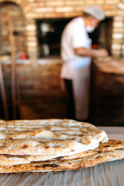 istock Traditional Turkish ramadan pita or pide bread with baker in bakery. 1301157773