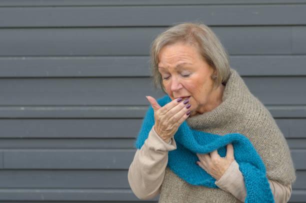 istock Elegant senior woman coughing into her hand 1301159448