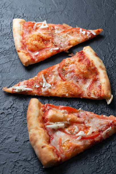 istock Tasty appetizing vegetarian pizza on dark stone background, top view 1301160204