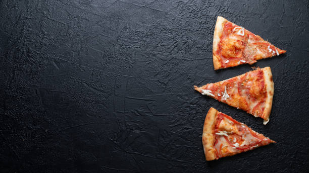 istock Tasty appetizing vegetarian pizza on dark stone background, top view 1301160215