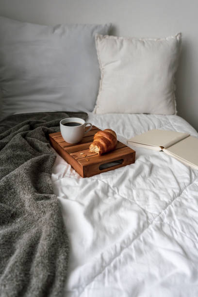 istock Breakfast in bed with a cup of coffee and a croissant 1301160281