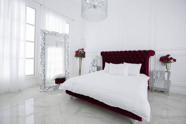istock Luxury white light bedroom interior design. Dark red large bed 1301160481