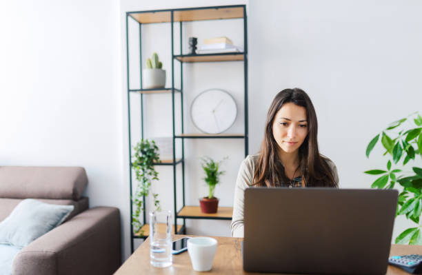 istock Young woman working on a laptop at home. Remote working / home office concept. 1301163055