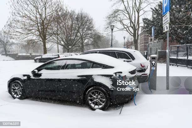 Electric Cars Charging At An Electric Vehicle Charging Station During A Cold Winter Day Stock Photo - Download Image Now