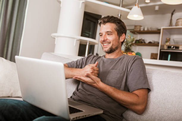 Young man showing gesture in sign language using laptop Young man showing gesture in sign language using laptop, make video call. sign language stock pictures, royalty-free photos & images