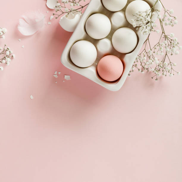 istock Easter eggs in white ceramic holder and flowers on pink background 1301164672