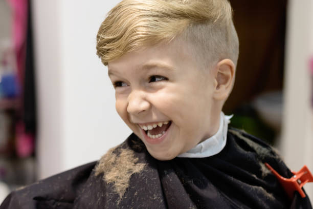 istock Happy boy having fun during haircut at barber shop. 1301164817