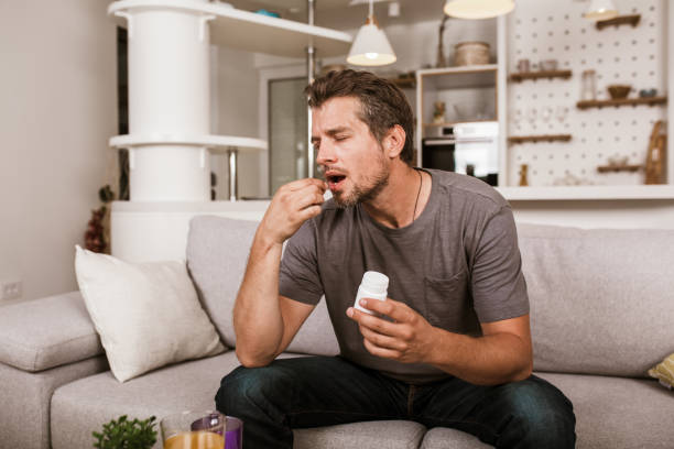 istock Handsome young man taking pill at home 1301167342
