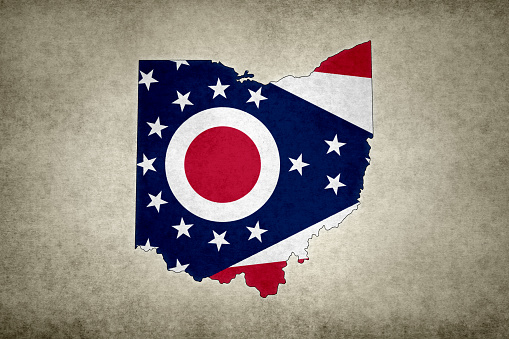 Grunge map of the state of Ohio (USA) with its flag printed within its border on an old paper.