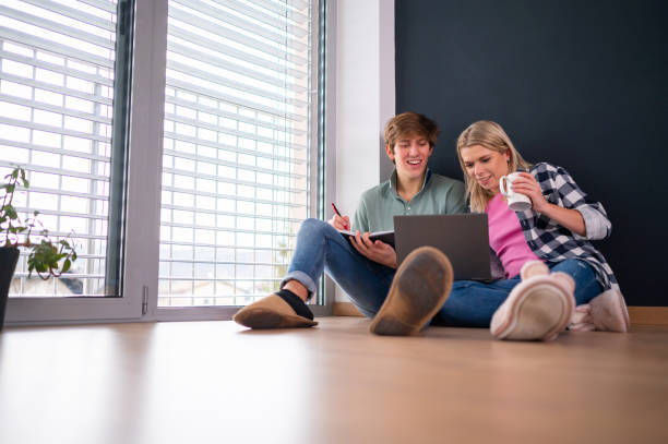 istock Young couple using laptop on the floor 1301169537