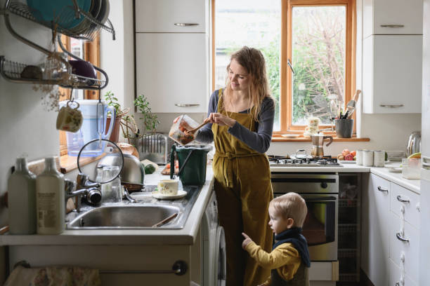 istock Mother with toddler putting food refuse in compost bin 1301169572
