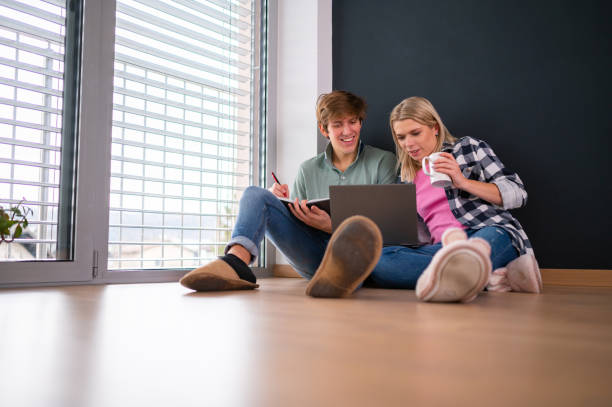 istock Young couple using laptop on the floor 1301169650
