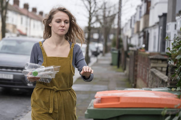 London, UK - November 17, 2024: Green bags with autumn leaves  on the street in london