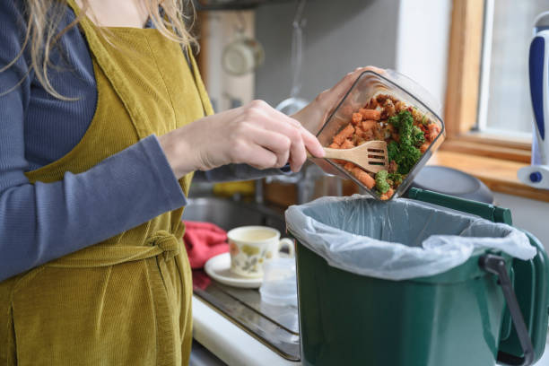 istock Caucasian woman adding vegetable remains to compost bin 1301169681