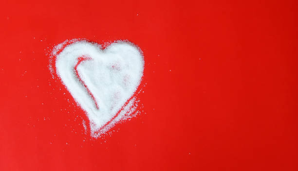 istock Sugar hearts shaped scrub isolated on red background 1301169786