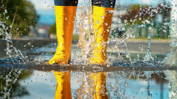 istock CLOSE UP: Glassy water splashes as unrecognizable woman jumps into a puddle. 1301170802