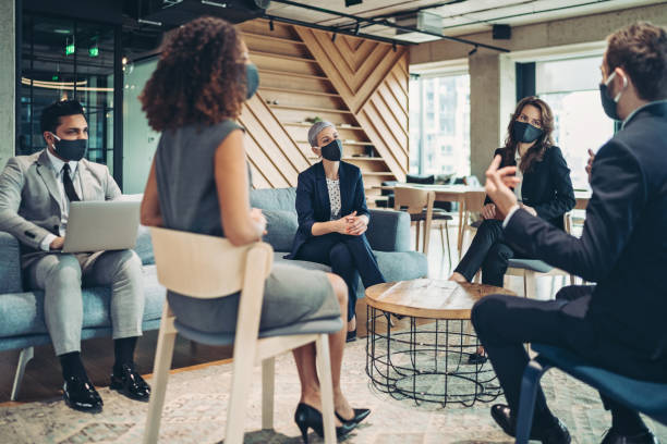 istock Group of entrepreneurs with protective masks having a discussion 1301171019