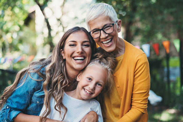 Three generations of femininity Portrait of happy grandmother, mother and daughter in the back yard adult offspring photos stock pictures, royalty-free photos & images