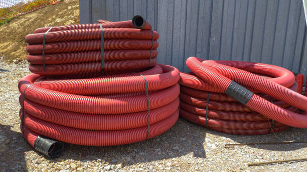 istock CLOSE UP: Two large coils of plastic conduits lay near a busy construction site. 1301171156