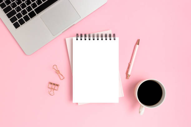 istock Workspace with laptop and notebook mockup on a pink background. 1301171636