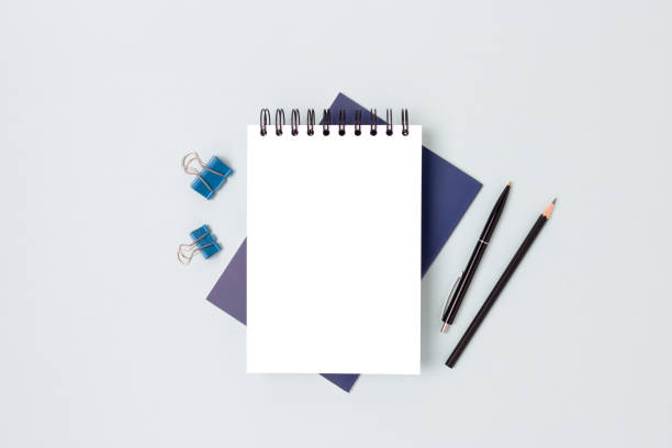 istock Workspace with blank notepad mockup and stationery on a blue background. 1301171755
