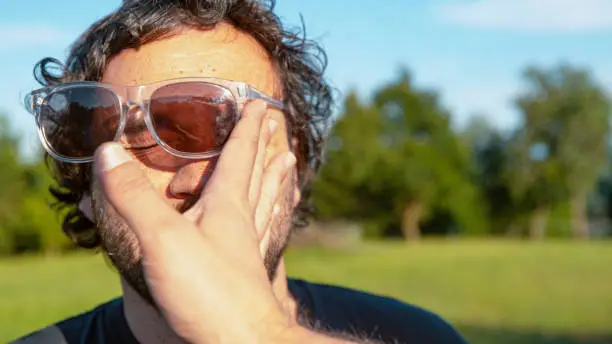 Photo of CLOSE UP: Man's sunglasses fly off face after getting slapped by unknown person.