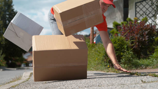 istock CLOSE UP: Clumsy delivery man falls to the ground and drops cardboard boxes 1301172468