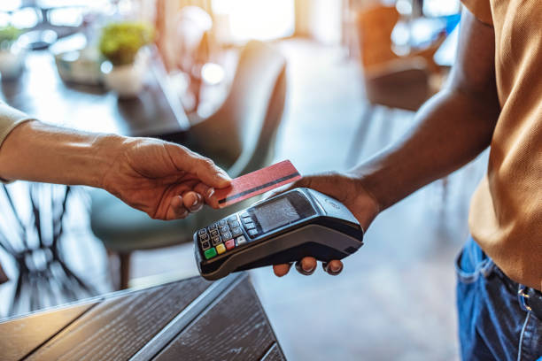 Close-up on a contactless payment at a cafe NFC Technology. Man giving credit card to waiter using modern contactless system at the bar station stock pictures, royalty-free photos & images