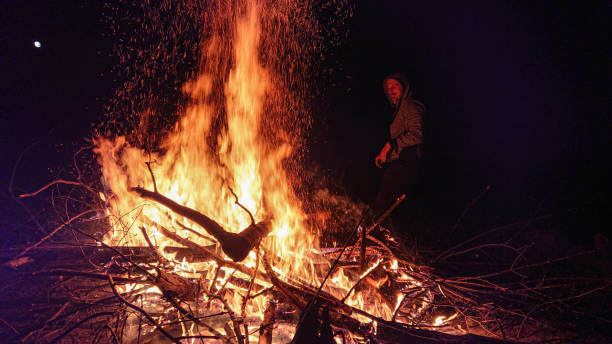 istock CLOSE UP: Cheerful man walks around a massive bonfire burning at midnight. 1301173008