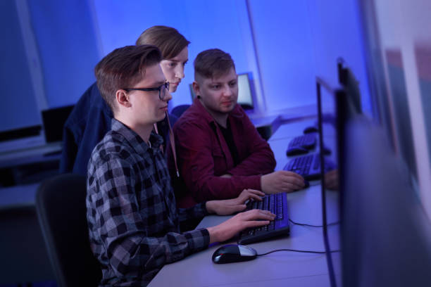 istock Two men and a woman discuss work while sitting in an office. Blue light. 1301173144