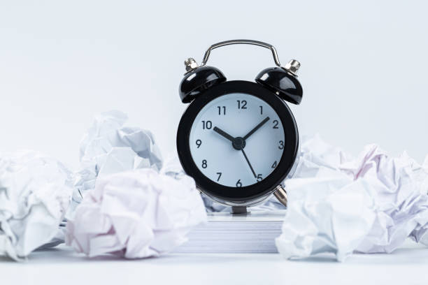 istock Alarm clock with crumpled paper balls.Timing and thinking idea concept. 1301173154