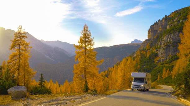 istock White recreational vehicle drives up empty mountain road on a sunny fall day 1301173688