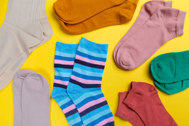 istock Multi-colored socks on a yellow background. View from above. Many different socks for cold seasons 1301174470