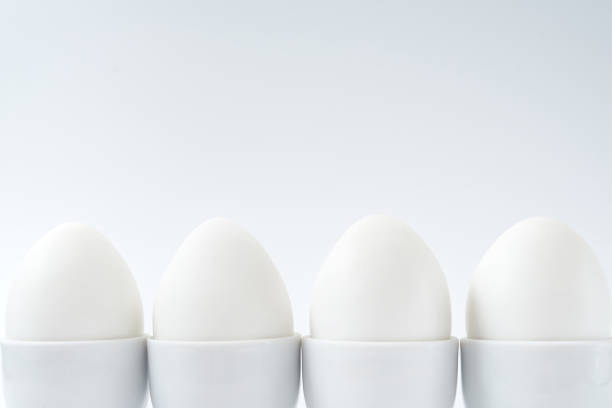 istock White eggs standing on egg cup isolated on white background, copy space. Row of boiled eggs in stand. Healthy food concept 1301174782