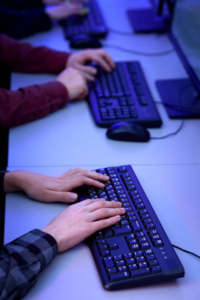 istock Female and male hands type text on a black keyboard. The work of a programmer. 1301174930