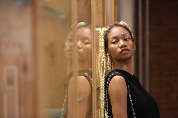 istock Young Woman Standing By Glass 1301174946