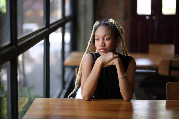 istock Young Woman Looking Away While Sitting At Cafe 1301174960