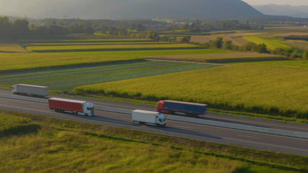 istock DRONE: Flying along two freight trucks hauling containers down country highway 1301175492
