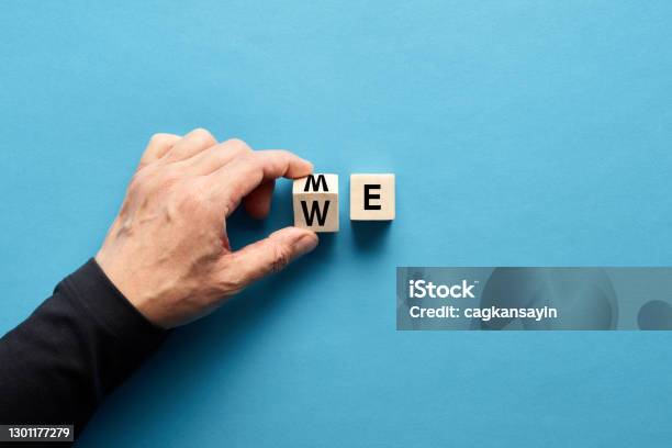 Male Hand Flipping Wooden Cube To Change The Word Me To We Teamwork Partnership Cooperation Team Collaboration Stock Photo - Download Image Now
