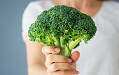 Raw broccoli in hand. Vegeterian food or diet concept