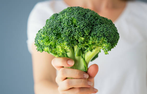 Raw broccoli in hand. Vegeterian food or diet concept stock photo