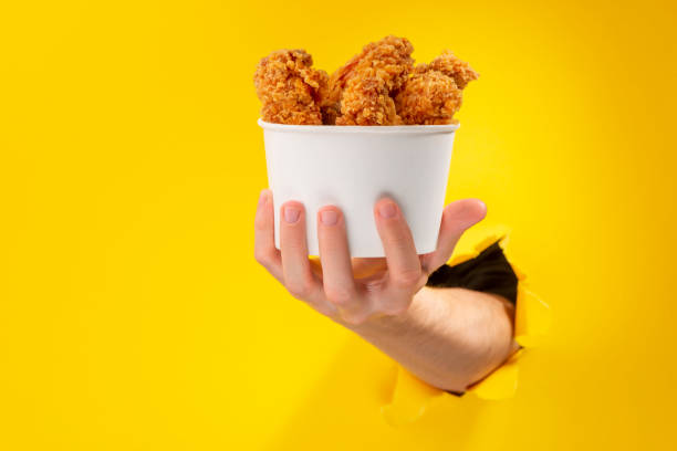 istock Hand giving a whole cup of chicken nuggets 1301179103