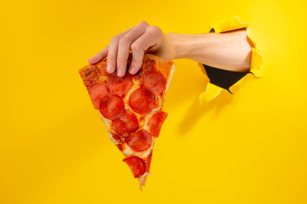 istock Hand giving a slice of Pepperoni pizza 1301180135