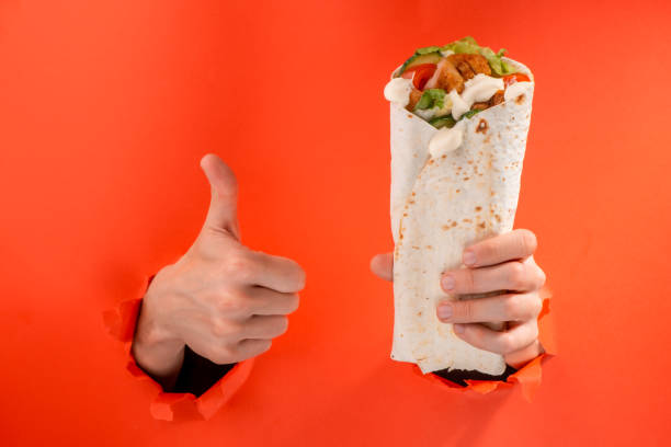 istock Hand holding a doner roll and showing a thumb up 1301180187