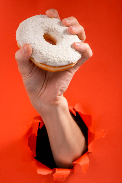 istock Hand showing a white doughnut with coconut 1301180752