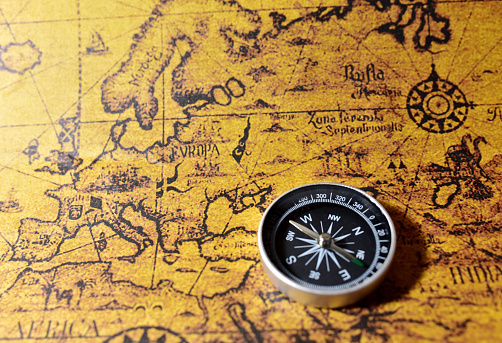 Compass on map. Tourist compass for orientation on the terrain. Magnetic declination alculator. Historical explorer help. Map reading and land navigation concept. Orient on maps
