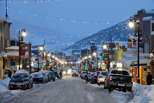 PARK CITY, UTAH, UNITED STATES OF AMERICA, MARCH 2019: Scenic shot of the snowy main street in downtown of Park City, Utah on a calm winter evening. Scenic ski resort village during Christmastime.