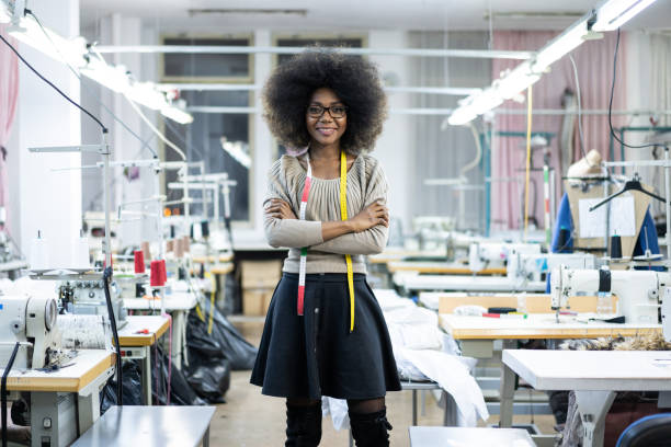 ritratto dello stilista africano con metro a nastro in fabbrica - sewing women tailor textile foto e immagini stock